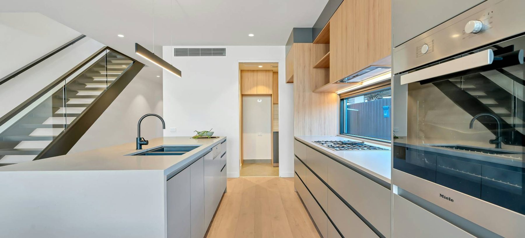 Kitchen with long stone bench and timber floors